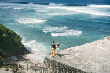 Loving couple on huge cliff above ocean