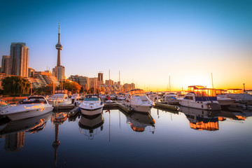 View of harbor in a yacht club at Toronto city during sunset with Canadian tower as background