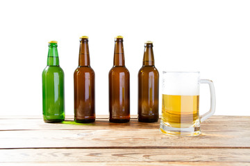 Glass and bottle of beer with no logos on wooden table isolated copy space, bottle mock up. Beer bottle studio shot with cap isolated.