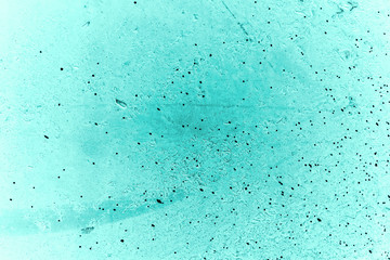 Vintage azure background. Rough painted wall of turquoise color. Imperfect plane of cyan colored. Uneven old decorative toned backdrop of aqzure tint. Texture of teal hue. Ornamental stony surface.