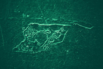 Vintage green background. Rough painted wall of emerald color. Imperfect plane of virid colored. Uneven old decorative toned backdrop of green tint. Texture of emerald hue. Ornamental stony surface.