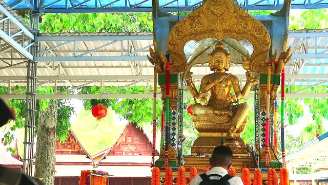 Tourist burning incense or joss stick to worship Phra Brahma