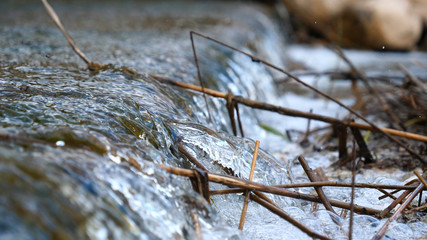 A worker cleaning waterfalls, cleans the waterfall from old branches and all other dirt. Concept of: Pure Nature, Shoe, Beautiful Nature, Slow Motion.