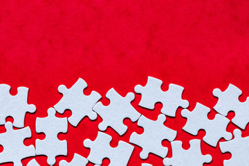 White jigsaw puzzle. White puzzle pieces on color background. Unfinished white jigsaw puzzle pieces on color background.