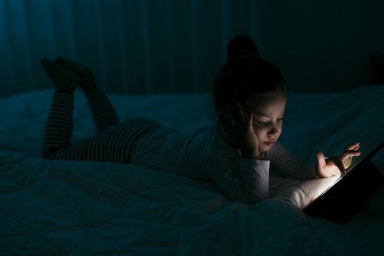 Girl with tablet In a dark room