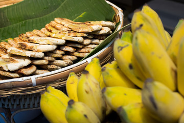 BBQ Banana on electronic fire heat oven, medium grill stack green banana leaf ready to sell, Thai...
