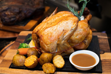Barbecue Roast whole body Turkey Chicken. slice by chief very gender, juicy and delicious, serve with potato, vegetable salad and sauces on wooden tray. very good look for commercial ads