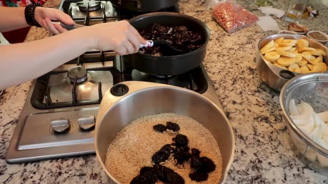 Side View. Woman taking out plums from the pot. Women making Mole in Puebla Mexico. North America.  Cooking Traditional recipe