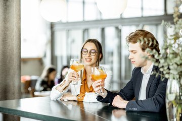 Business partners having unofficial meeting, drinking together some cocktails at the bar