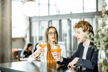 Business partners having unofficial meeting, drinking together some cocktails at the bar