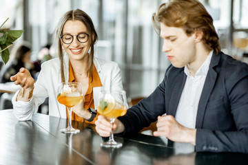 Business partners having unofficial meeting, drinking together some cocktails at the bar