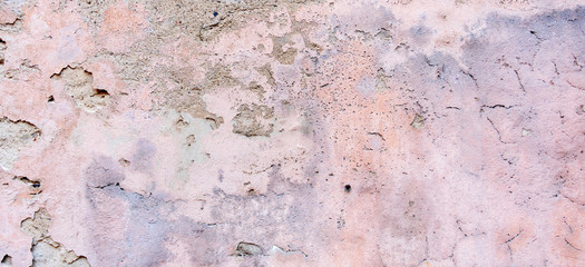 Old weathered painted wall background texture. White grey pink dirty peeled plaster wall with falling off flakes of paint