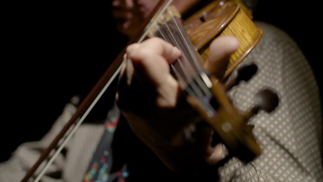 man playing the viola in slow motion with black background 
