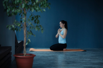young girl doing yoga on the mat in the studio with folded hands in prayer pose namaste.soft focus...