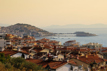 BODRUM, TURKEY - JUNE 15, 2017: Red-tiled house roofs and the Mediterranean Sea at sunset