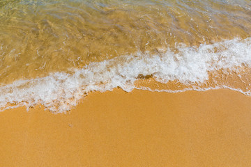 Soft wave of blue ocean on sandy tropical beach. Background of tropical paradise beach with golden sand, travel tourism panorama background concept. Sand and sea waves background.