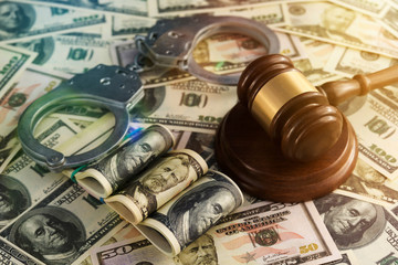 handcuffs, the judge's hammer against the American dollar bills. financial crimes, corruption.