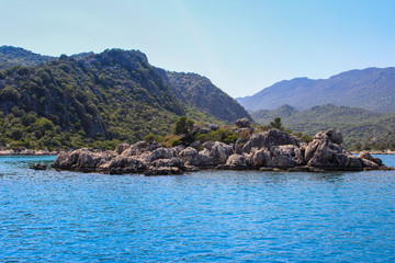 Fototapeta na wymiar Rocks and bright turquoise water in the Mediterranean Sea.