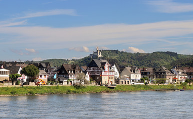 Fototapeta na wymiar Riverside village on the Rhine river in Germany with hilltop castle in the background