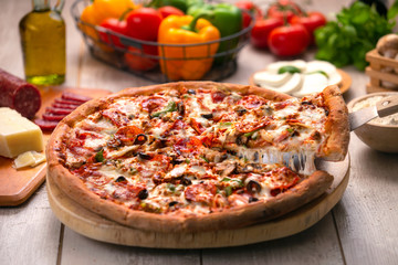 Delicious supreme pizza, deluxe toppings loaded with extra fresh ingredients, stringy cheese lifted...