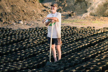 Man Laughs While Amongst His Farm Equipment