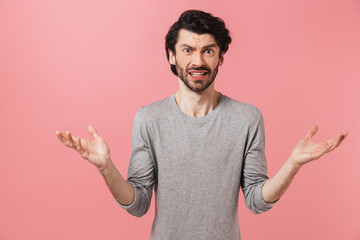 Young confused bearded brunette man