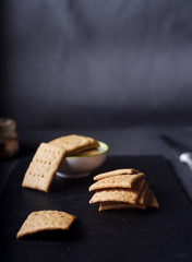 Homemade whole wheat crackers on dark background