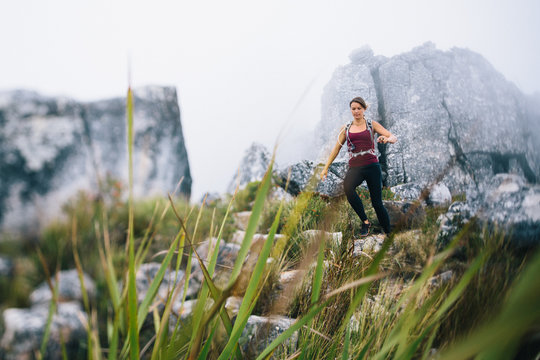 Female trail runner in misty mountains