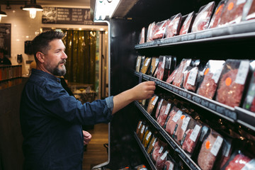 Man shopping for meat in grocery store