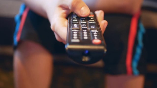 TV remote control close-up. Change channels on the TV remote. Hand using tv remote control