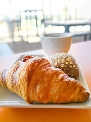 Breakfast with coffee and croissants on table