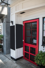 Fototapeta premium Red restaurant door with a closed sign in the window. There are two chalk blank boards near the door