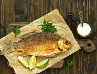 Fried carp with onions and white sauce.