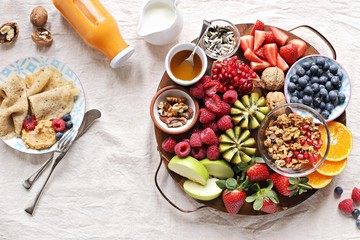 Healthy breakfast board included granola, fruits and berries selection, nuts and honey. Plant based, clean eating, super food, vegetarian concepts.