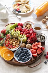 Healthy breakfast board included granola, fruits and berries selection, nuts and honey. Plant based, clean eating, super food, vegetarian concepts.