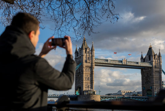 Man taking pictures to the Tower Bridge in London
