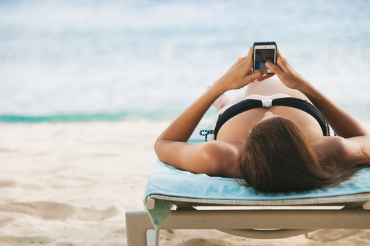 Tropical: Woman Using A Cel Phone While At The Beach