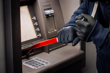 thief with crowbar opens the ATM. © kaninstudio