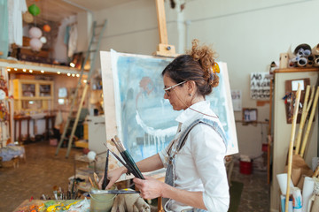 Artist woman drawing a model in her studio.