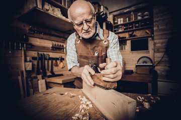 old carpenter work with the hand plane