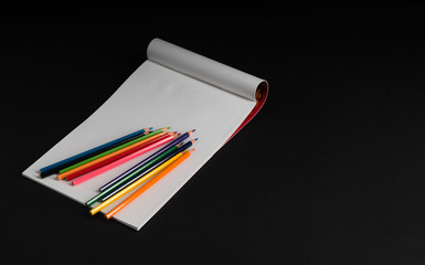 album for drawing and color pencils on a black background, isolated. back to school