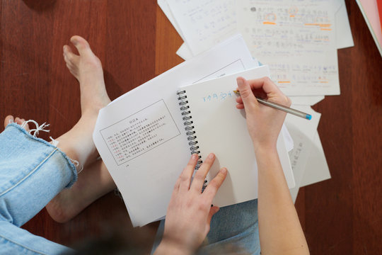 Crop woman writing in notepad