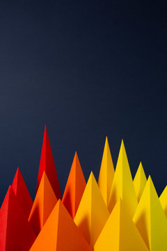 Red, Orange and Yellow paper pyramids on a navy background, (2)