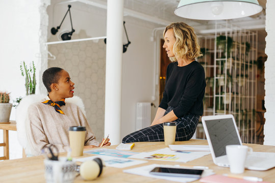 Female co-workers talking in a modern office.