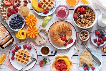 Happy breakfast with granola, croissant, fresh waffles, fruits and berries.  - obrazy, fototapety, plakaty