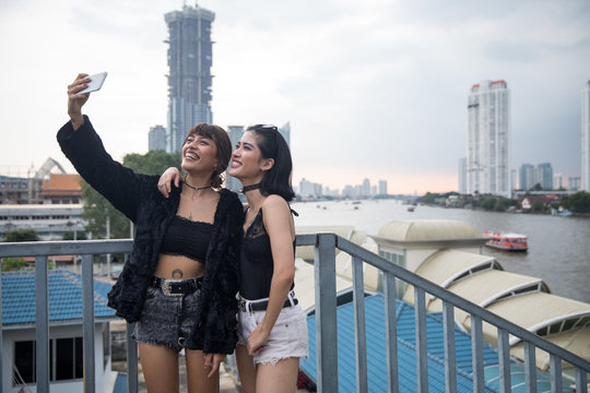 Two girlfriends taking a selfie together in the city