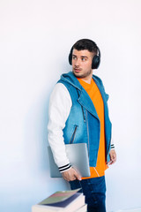 Fototapeta premium Side view of young man in casual clothes standing while looking away and carrying a tablet pc.
