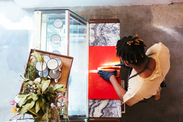 Overhead of an employee cutting bacon.
