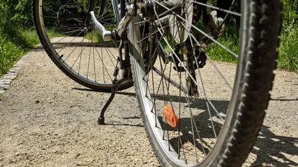 Stojący rower na drodze w słoneczny dzień - obrazy, fototapety, plakaty