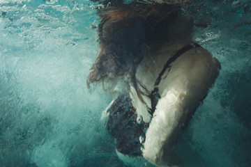 Woman coming up for air while swimming in crystal blue water
